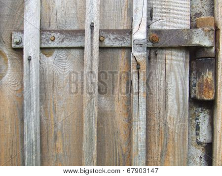 Rusty hinges on the old wooden gate from boards
