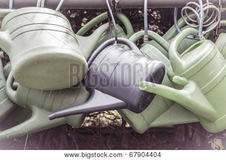Some Old Watering Cans On A Rusty Pipe