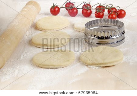 Mini Pizza Dough On A Floury Wooden Board