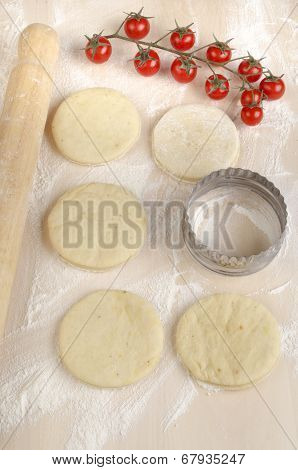 Mini Pizza Dough On A Floury Wooden Board