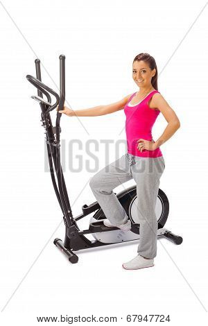 Young Woman Uses Elliptical Cross Trainer.