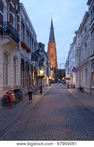 MAASTRICHT, NETHERLANDS - SEPTEMBER 7, 2013: Rechtstraat and the spire of St. Maartenskerk church. Built in 1858 by Pierre Cuypers, this neo-gothic church is one of landmarks of Wijck district