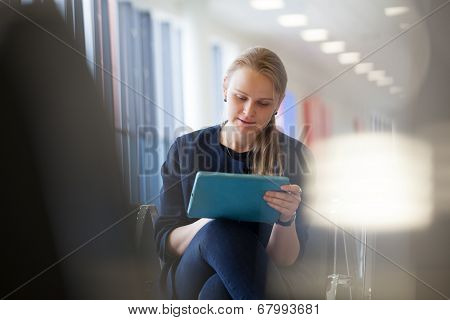 Young woman with pad in the waiting room
