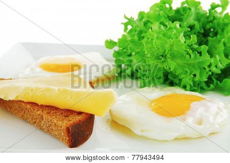 fried eggs and gold cheese on white plate