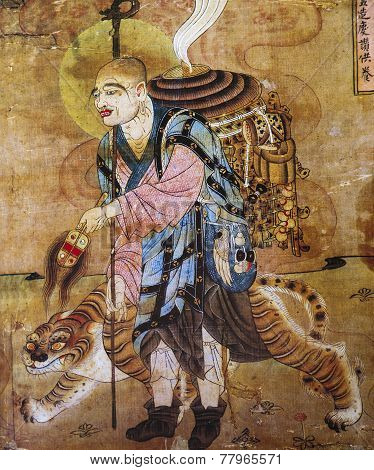 Chinese fresco of a monk and tiger in cave Dunhuang, China