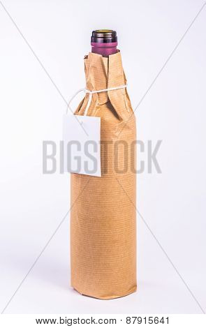 isolated one bottle wrapped in paper with clean blank card
