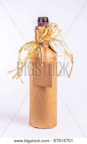 bottle wrapped in paper with decoration and clean card