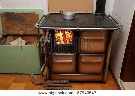 Antique Stove A Wood-burning Stove With Fire Lit In The Old Mountain Home