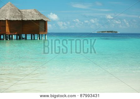 View of beautiful blue ocean water and bungalows in Baros Maldives