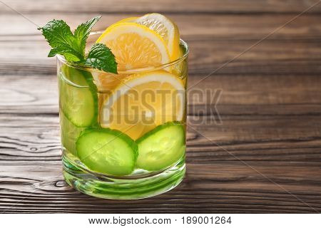 cool drink with lemon and mint on a wooden background