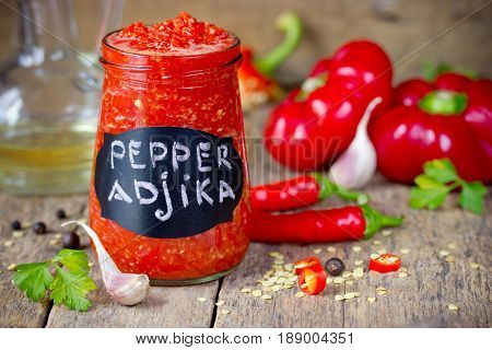 Spicy pepper adjika in a glass jar