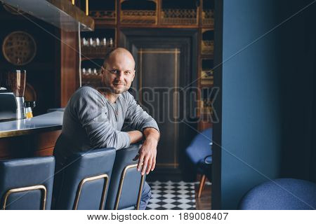 handsome young man sitting at a bar counter