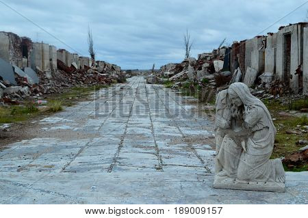 Religious statue witnessing the destruction of nature in a cemetery in the province of Buenos Aires