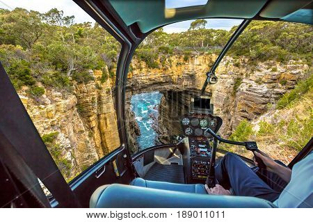 Helicopter cockpit with pilot arm and control console inside the cabin on Tasman Arch in the Tasman National Park, Tasman Peninsula south east coast of Tasmania, Australia.