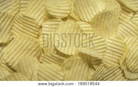 Close up crispy potato chips top view backgrounde. Ruffles form.