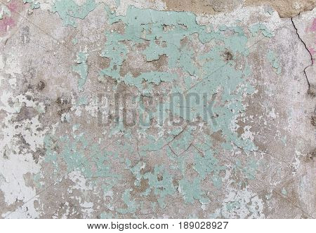 Old painted wall. Green and damage surface. Peeling paint background. Stone demaged backdrop