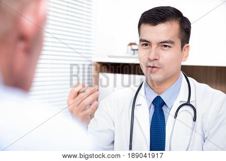 Doctor talking with senior male patient - medical consultation and examination concepts