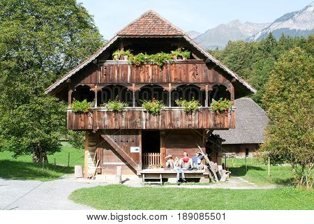 People Taking A Rest At Old Farm House In Ballenberg
