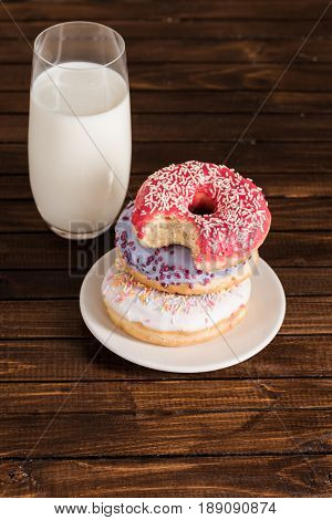 Close Up Of Glass Of Milk With Donuts On Plate On Wooden Background