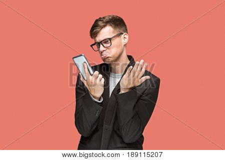 The young caucasian businessman in glasses on red studio background talking on cell phone
