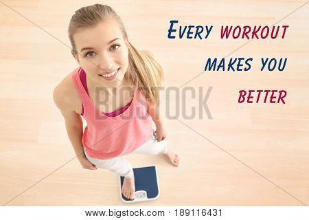 Weight loss motivation concept. Young woman standing on scales at home. Text EVERY WORKOUT MAKES YOU BETTER on background
