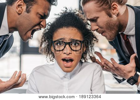 Two Emotional Businessmen In Formalwear Screaming On Businesswoman In Office, Multicultural Business