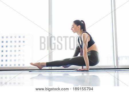 Young Attractive Woman Practicing Yoga, Sitting In Exercise, Working Out, Wearing Sportswear At Floo