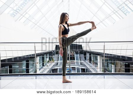 Extended Hand-to-big-toe Pose. Beautiful Yoga Woman Practice In A Big Business Hall Background. Yoga