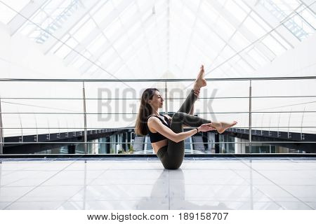 Beautiful Yoga Woman Practice In A Big Business Hall Background. Yoga Concept.