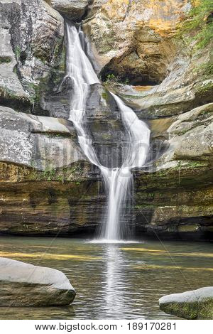 Cedar Falls a beautiful waterfall in the Hocking Hills of Ohio splits into two streams and reunites before plunging into the pool below.