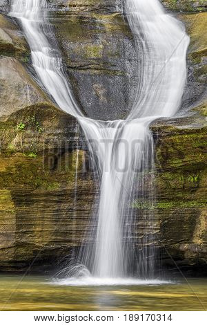 Cedar Falls a beautiful waterfall in the Hocking Hills of Ohio splits into two streams and reunites before plunging into the pool below.