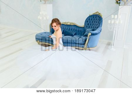 Beautiful young bride in a luxury dress in elegant interio