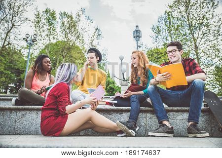 Multi-ethnic group of students stdying together outdoors in a college campus