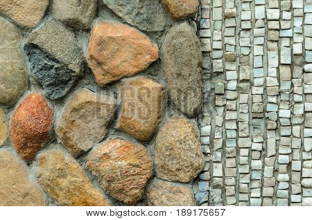 The junction of a cobblestone wall and a shallow mosaic. Wall with various finishes with natural stone. Mixed finishing wall