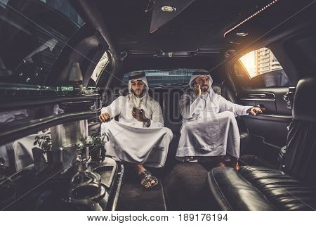 Arabic businessmen in Dubai driving on a limousine