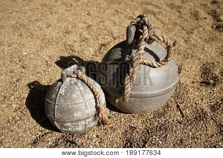 Two old fishing net metal balls on the beach