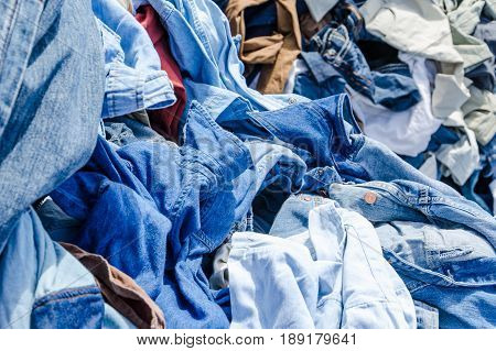 Heaps of clothing on the second hand market. Pile of second hand clothes at a garage sales
