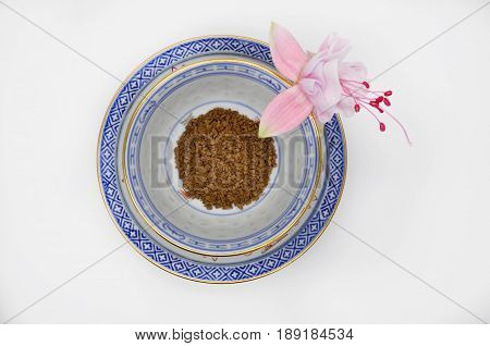 one pink flower fuchsia and black instant coffee in a small Cup and saucer