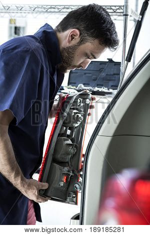 Car Mechanic Man At The Garage Fixing The Engine