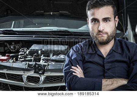 Car Mechanic Man At The Garage Fixing The Engine