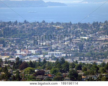 SEATTLE-- JUNE 25: Aerial view of Small Plane Flies over Seattle with Puget Sound in the distance on June 25 2016 in Seattle WA.