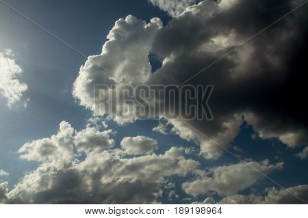 Cumulus clouds float away to the right as if under the pressure of the luminous flux of the sun.