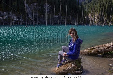 Young woman at Kaindy lake Tien Shan mountain Kazakhstan.