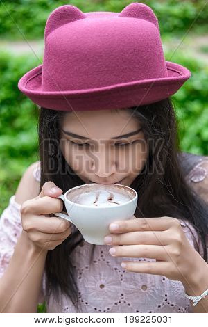 Asian woman relaxing on couch with coffee at water fall cafe.Close up
