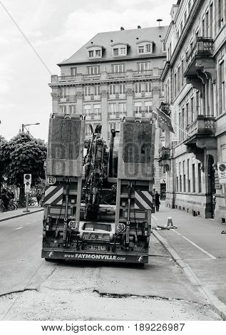 STRASBOURG FRANCE - MAY 18 2016: Rear view of Mercedes-Benz Actros 2660 truck transporting construction excavator at the construction site in urban environment during roadwork - truck excavator transport