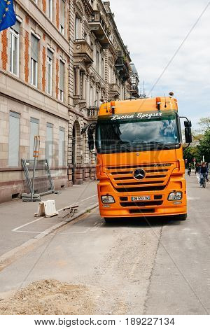 STRASBOURG FRANCE - MAY 18 2016: Mercedes-Benz Actros 2660 truck transporting construction excavator at the construction site in urban environment during roadwork