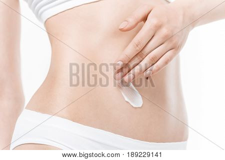 Close-up Partial View Of Woman In Underwear Applying Body Cream On Belly
