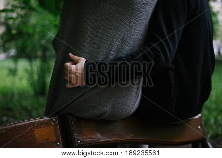 cuople huging in city park while sitting on a bench view from back