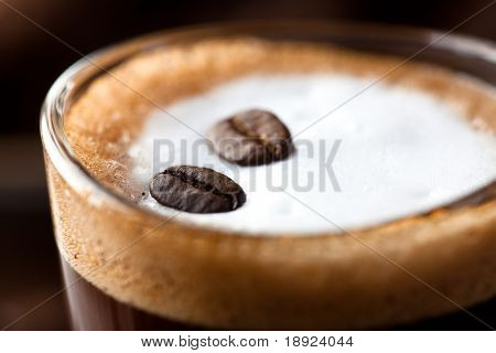 Close up di Caffe Macchiato con chicchi di caffè