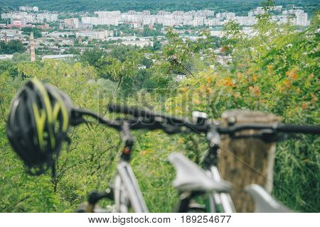 two bicycles stand on hill wth city view on background